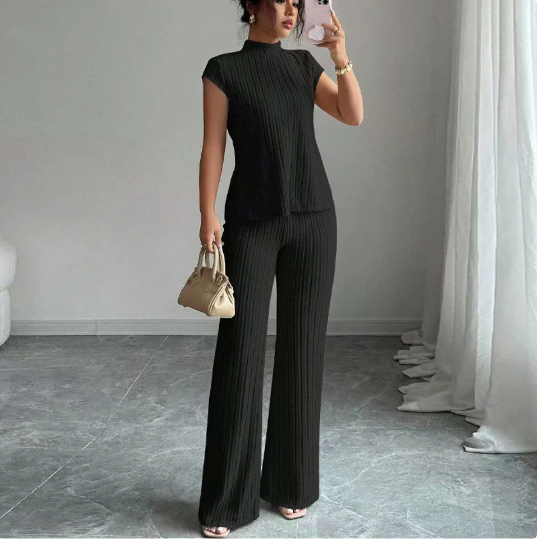 Completo a due pezzi composto da un elegante top a collo alto e pantaloni a gamba larga.