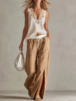 Completo casual da donna in cotone e lino: top senza maniche con scollo a V e vestibilità ampia e pantaloni a gamba larga a vita alta.